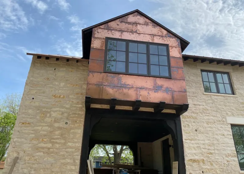 Copper metal panel facade on a stone building for Roof Repair in Greenbriar